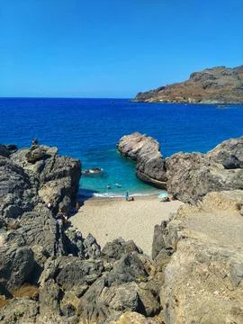 Secluded Beach Surrounded by Cliffs and Blue Sea in Crete, Greece Stock Photos