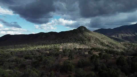 A secluded desert mountain with dramatic clouds and light Stock Footage 311021661