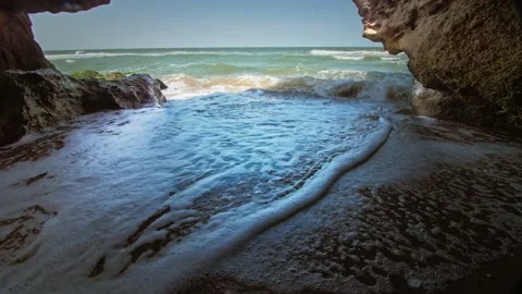 A secluded hideaway on the seashore, protected from all sides. The waves crash Stock Footage 220633306