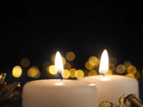 Second Advent candle burning with blurred Christmas lights Stock Photos
