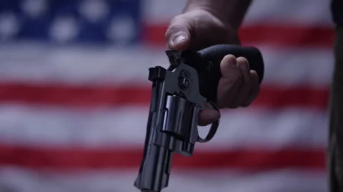 Second Amendment - Disarming america uncocking the gun in front of the flag Stock Footage 300899942