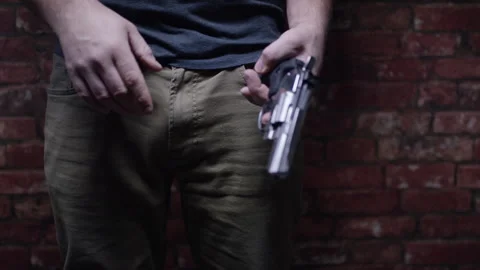 Second Amendment - Man holding revolver in front of brick wall Stock Footage 301041277