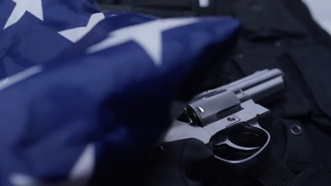 Second Amendment - Pulling flag to reveal police vest and gun Stock Footage 301008114