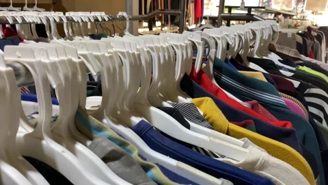 Second clothes hanging on a rack in a flea market Stock Footage 248321438