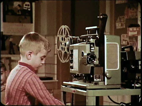 A second grader demonstrates how to set up and operate a film projector in 1964. Stock Footage 74936848