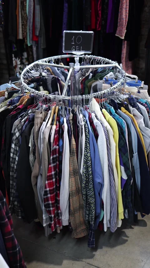 Second hand clothing rack with shirts affordable fashion shopping Stock Footage 330904178