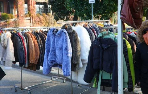 Second hand winter clothes and vintage coats on display at a street flea ma.. Fotos Stock