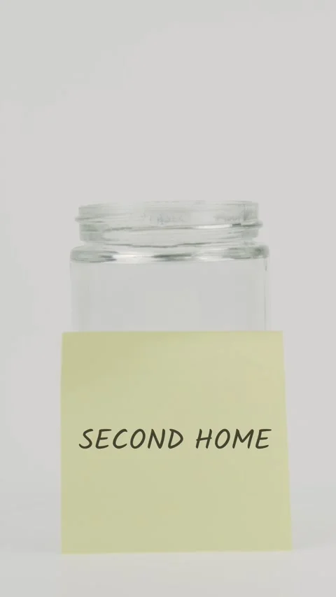 Second home text or word on yellow sticky note attached to glass jar Stock Footage 311785030