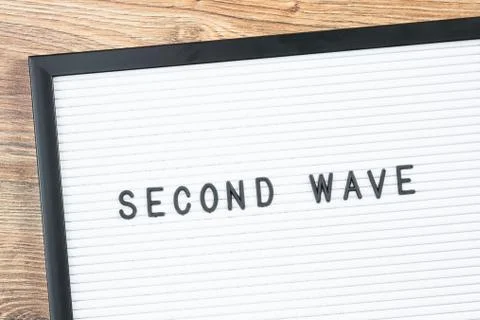 Second Wave text warning on letter board. Stock Photos
