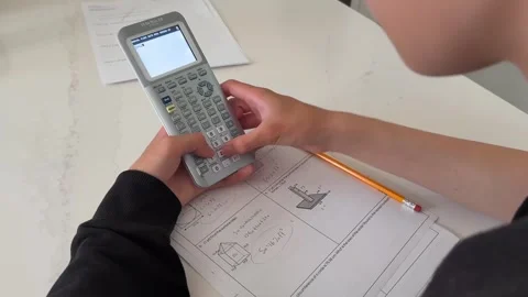 Secondary School Student Solving A Math Problem Using The Classic TI-84 Plus CE Stock Footage 336411552
