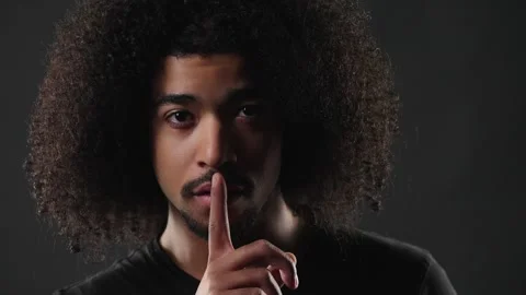 Secrecy And Confidentiality Concept, Young Man With Afro Hair Gesturing Silence Stock Footage 335934175