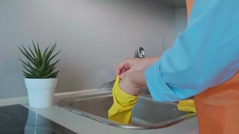 The secret to easy kitchen cleaning is the right products. Woman cleans the sink Stock Footage 301869077
