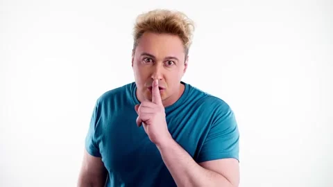 Secret, mystery man keeps index finger on lips, makes silence gesture Stock Footage 237694132