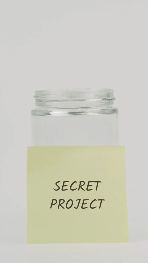 Secret project text or word on yellow sticky note attached to glass jar Stock Footage 311785189