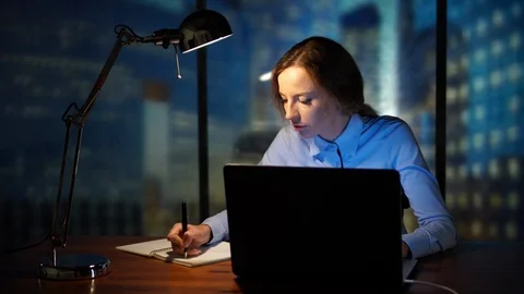 Secretary at the office writing in the notebook, using computer, laptop Stock Footage 95399381