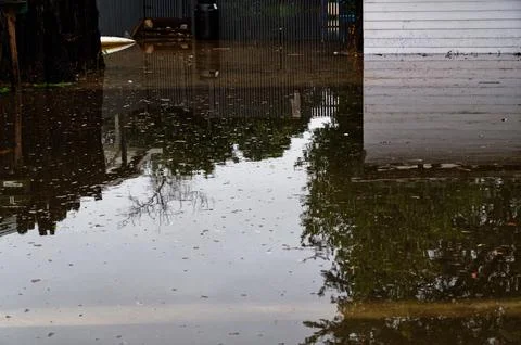 A section and road has been inundated by flood waters due to heavy rain Stock Photos