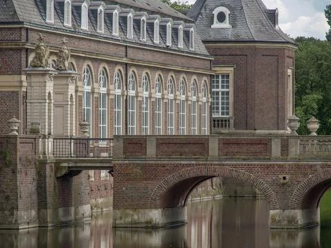 A section of a castle with a classical bridge leading over a moat, surrounded by Stock Photos
