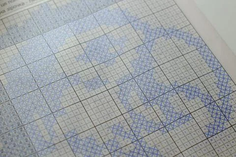 A section of a cross-stitch chart features blue patterned stitches Stock Photos