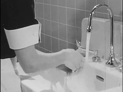 A section of a handwashing tutorial video from the 1960s shows a nurse Stock Footage 74998805