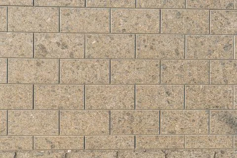 Section of a mottled, continuous wall made of rectangular, non-mortared sto.. 스톡 사진