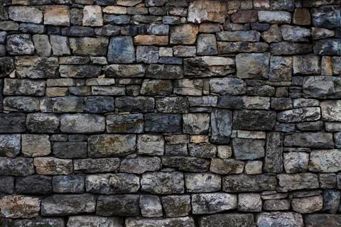Section of an old granite stone wall with failing mortar and no pointing. Stock Photos