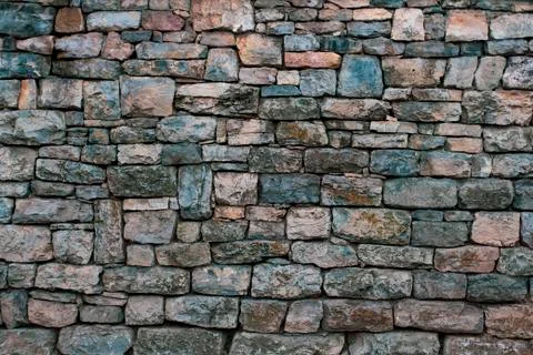 Section of an old granite stone wall with failing mortar. Stock Photos