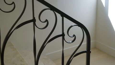 Section of staircase railing with intricate wrought iron designs. Railing Stock Footage 294854016