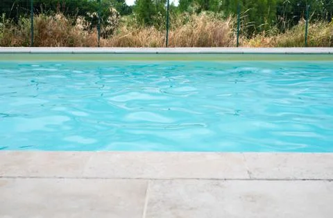 Section of swimming pool with stone surround Stock Photos