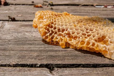 Section of wax honeycomb from beehive on the vintage wooden background. Stock Photos