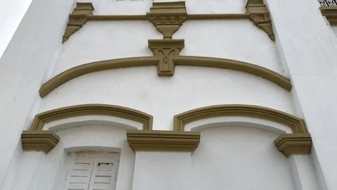 A section of a white building facade highlighted by olive green moldings, cor Foto stock