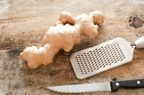 Section of whole raw root ginger on a rustic table Stock Photos