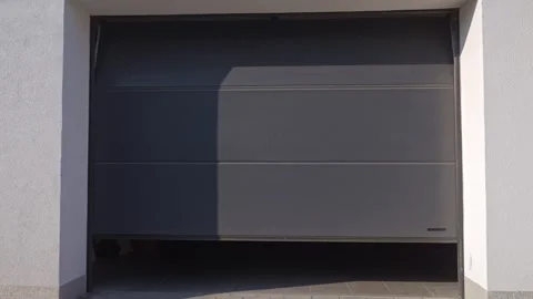 Sectional garage door is closing with storage items visible inside Stock Footage 334074954