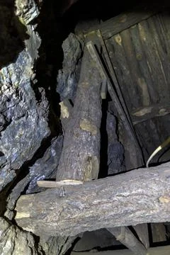 Sections of timber hold a wood platform up between the rocks in a mine Stock Photos