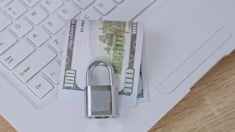 Secure banking concept with metal padlock resting on stack of hundred-dollar Stock Footage 328591926