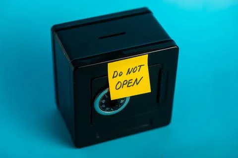 Secure black safe with "do not open" sticky note against bright blue backgrou Stock Photos