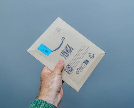 A Secure Delivery: Hand Holding a Amazon Prime Parcel. Stock Photos