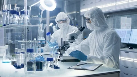 In a Secure High Level Laboratory Scientists in a Coverall Conducting a Research Stock Footage 75467613