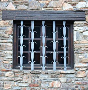 Secure metal patterned lattice is installed on the window of the stone struct Stock Photos