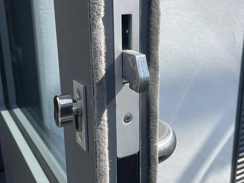 Secure modern chrome door lock with thumb turn lock and handle, on exit door Foto stock