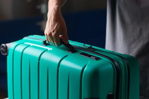 Secure suitcase with combo lock, Hands set combination on teal suitcase with Stock Photos