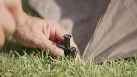 Securing a Camping Tent with a Ground Stake Stock-Footage 346534083