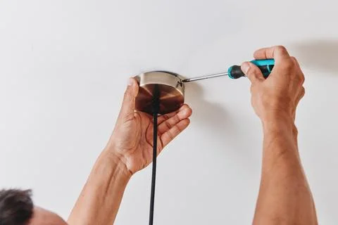 Securing a ceiling light canopy with a screwdriver Stock Photos