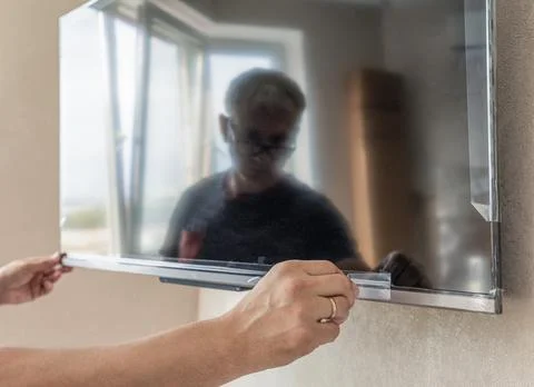 Securing the flat screen TV to the wall. Stock Photos