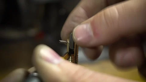 Securing a flint wheel inside a metal lighter mechanism Stock Footage 317137906