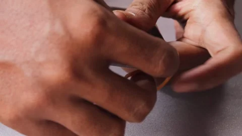 Securing a slightly lifted smartphone screen with a rubber band Stock Footage 345103489