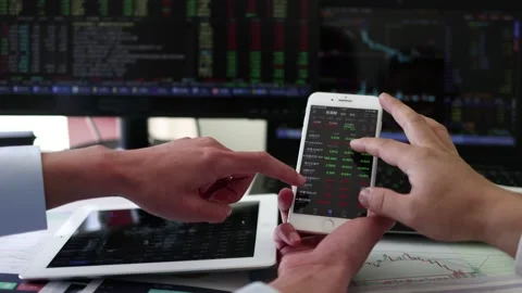 A securities analyst who uses his mobile phone to view stocks Stock Footage 165790410
