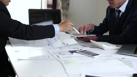 Securities analysts are discussing and exchanging stock market data graphs Stock Footage 223283350