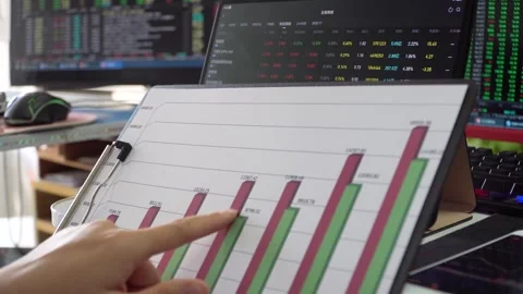 Securities analysts are studying and discussing stock quotes and data charts Stock Footage 303548188