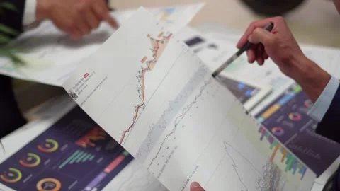 Securities analysts study and discuss K-line data of stocks Stock Footage 155731845