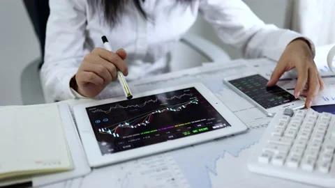 Securities analysts use tablets to watch and trade stocks Stock Footage 168963734